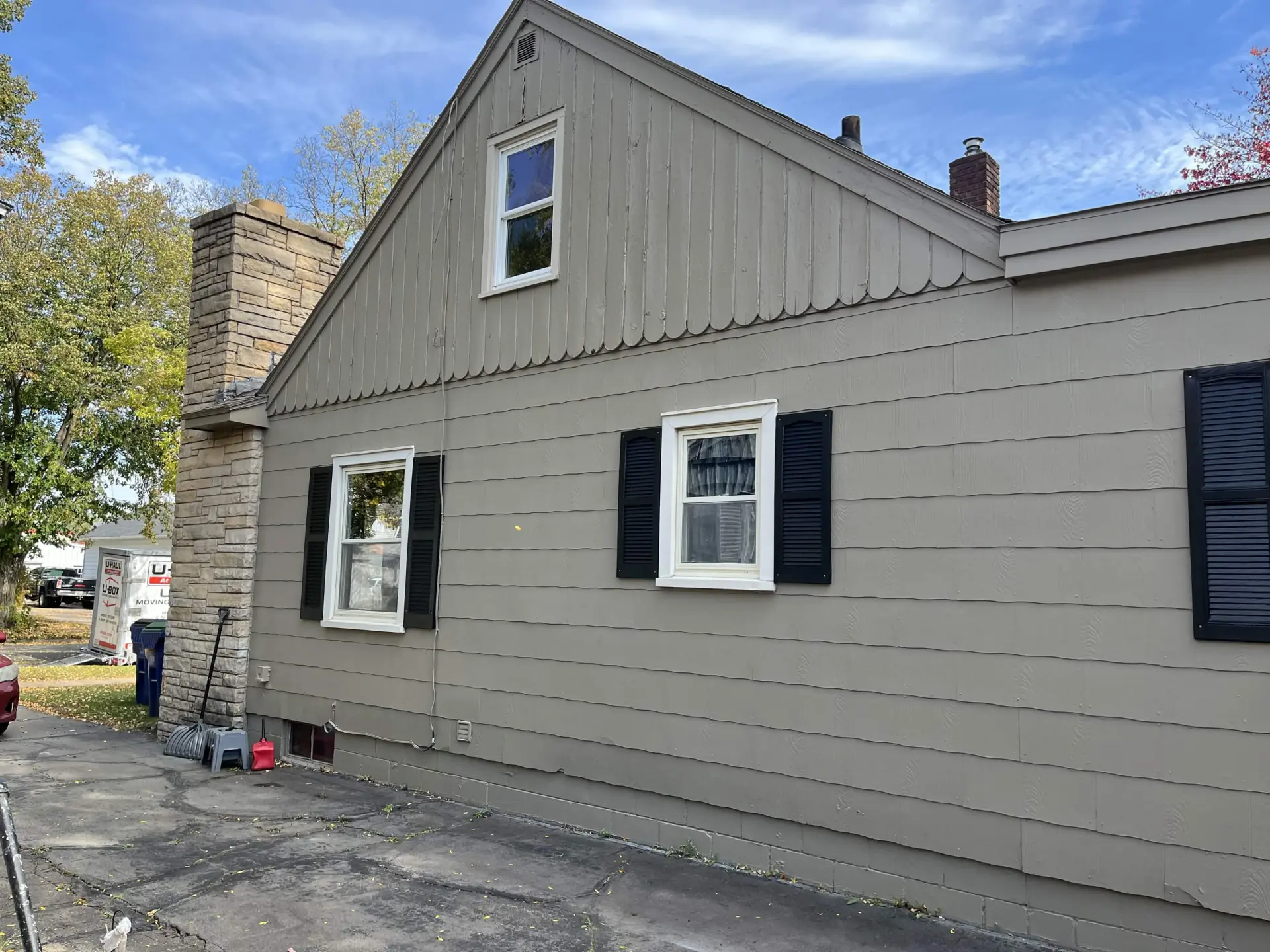 Side of the Weston home after the repaint: khaki gray lap siding and gable, cream window trim and black shutters.